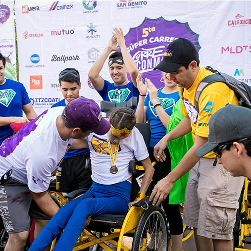 Un niño en silla de ruedas recibe una medalla de voluntarios disfrazados de superhéroes